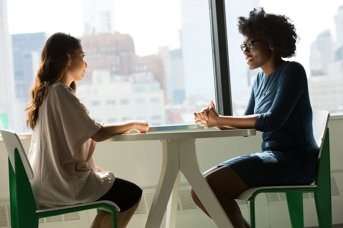 Two people talking across a table in an interview